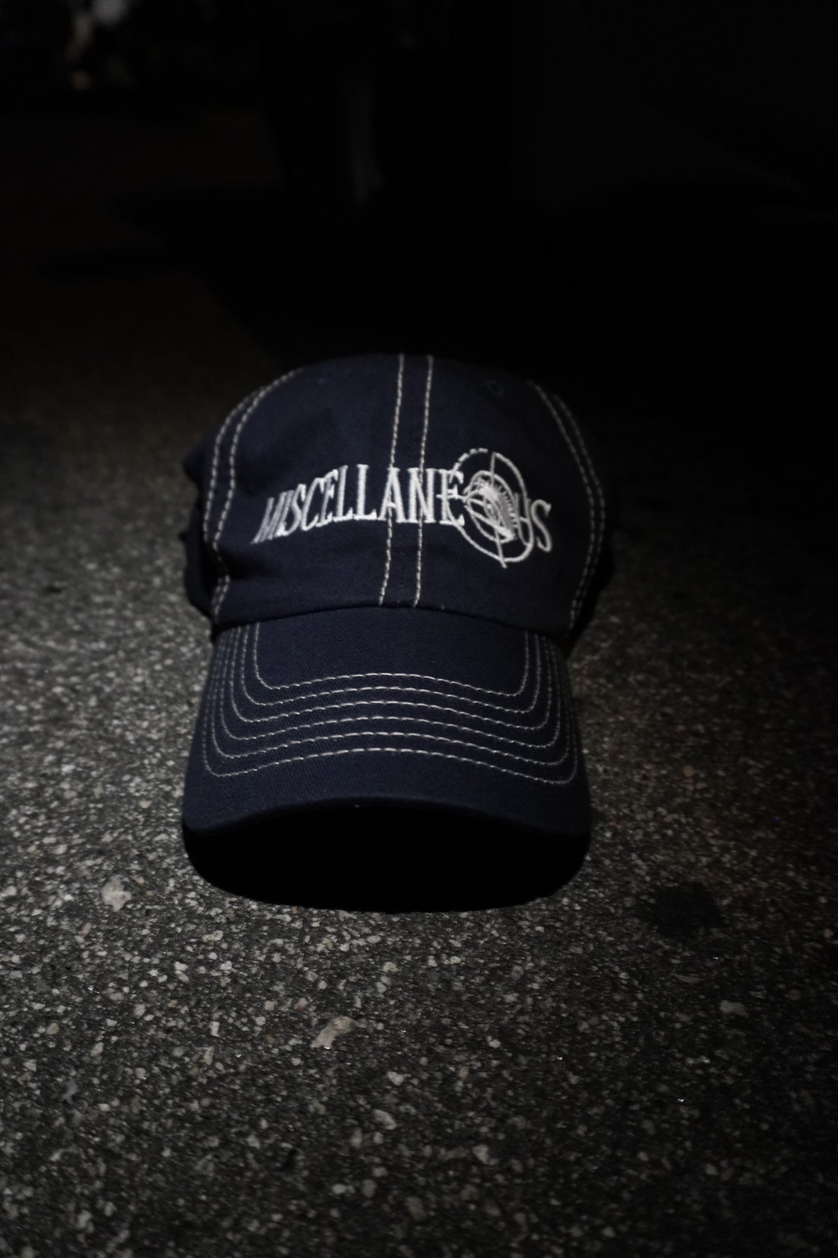 Navy dad hat with stone contrast stitching and white embroidered Miscellaneous logo