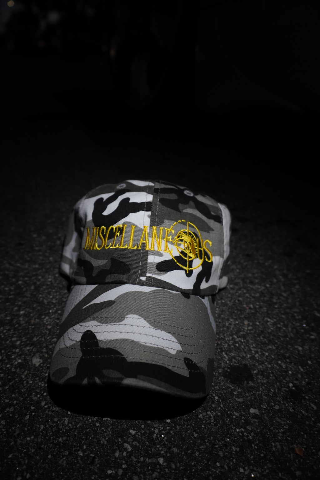 Gray camo dad hat with gold embroidered Miscellaneous logo
