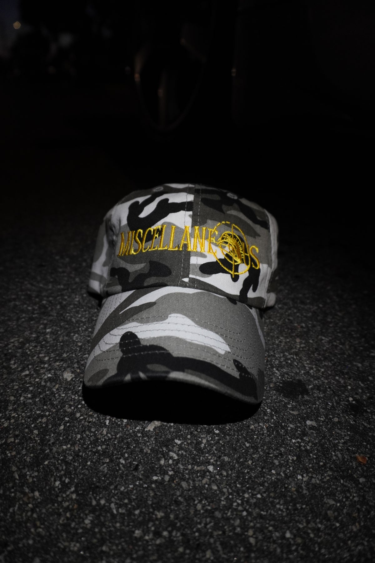 Gray camo dad hat with gold embroidered Miscellaneous logo